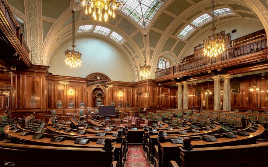 Une salle de conseil lambrissée avec ses rangées de sièges
