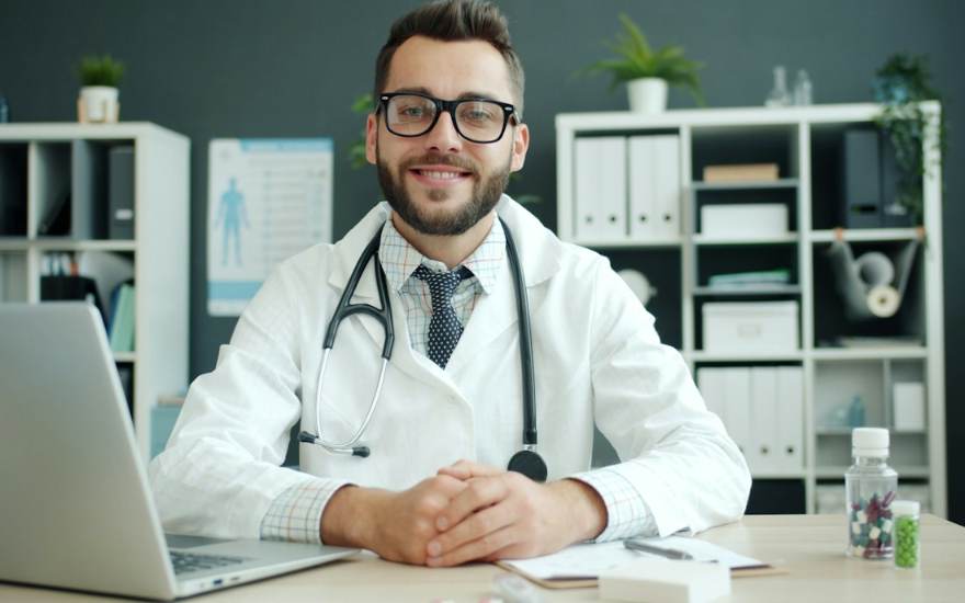 Un médecin à son bureau, stéthoscope autour du cou