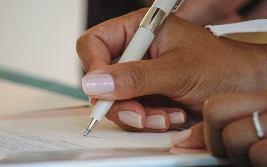 Une personne écrit à son bureau
