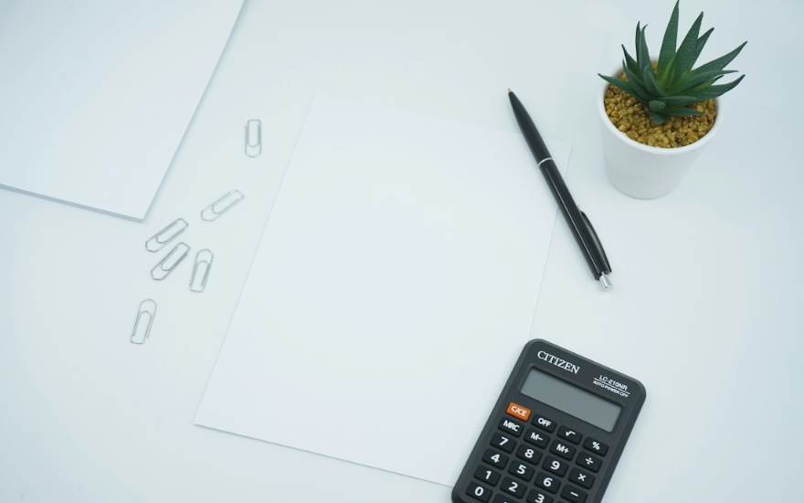 Une calculatrice, un stylo et une feuille blanche