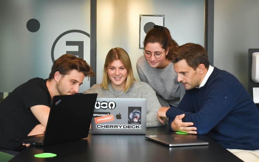 Quatre collègues autour d'un ordinateur portable